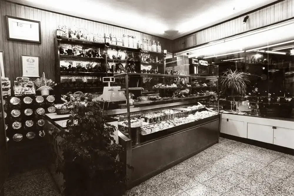 Interior de la pastelería en sus primeros años, con las vitrinas de madera originales